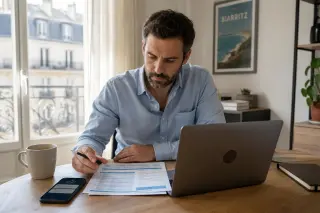 travailleur indépendant seul dans un bureau moderne, consultant un arrêt maladie et des documents administratifs devant son ordinateur, ambiance lumineuse et calme